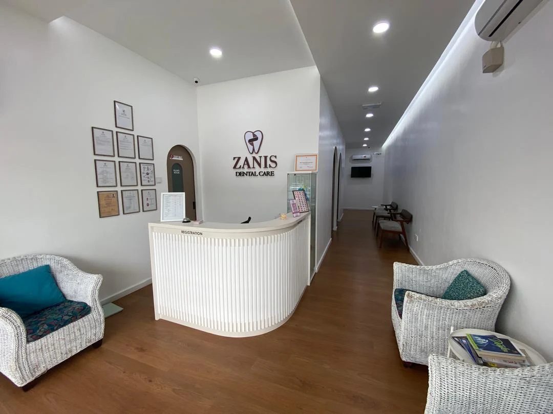 Zanis Dental Care reception area, with wicker seating, wood flooring and the clinic's tooth-mark signage